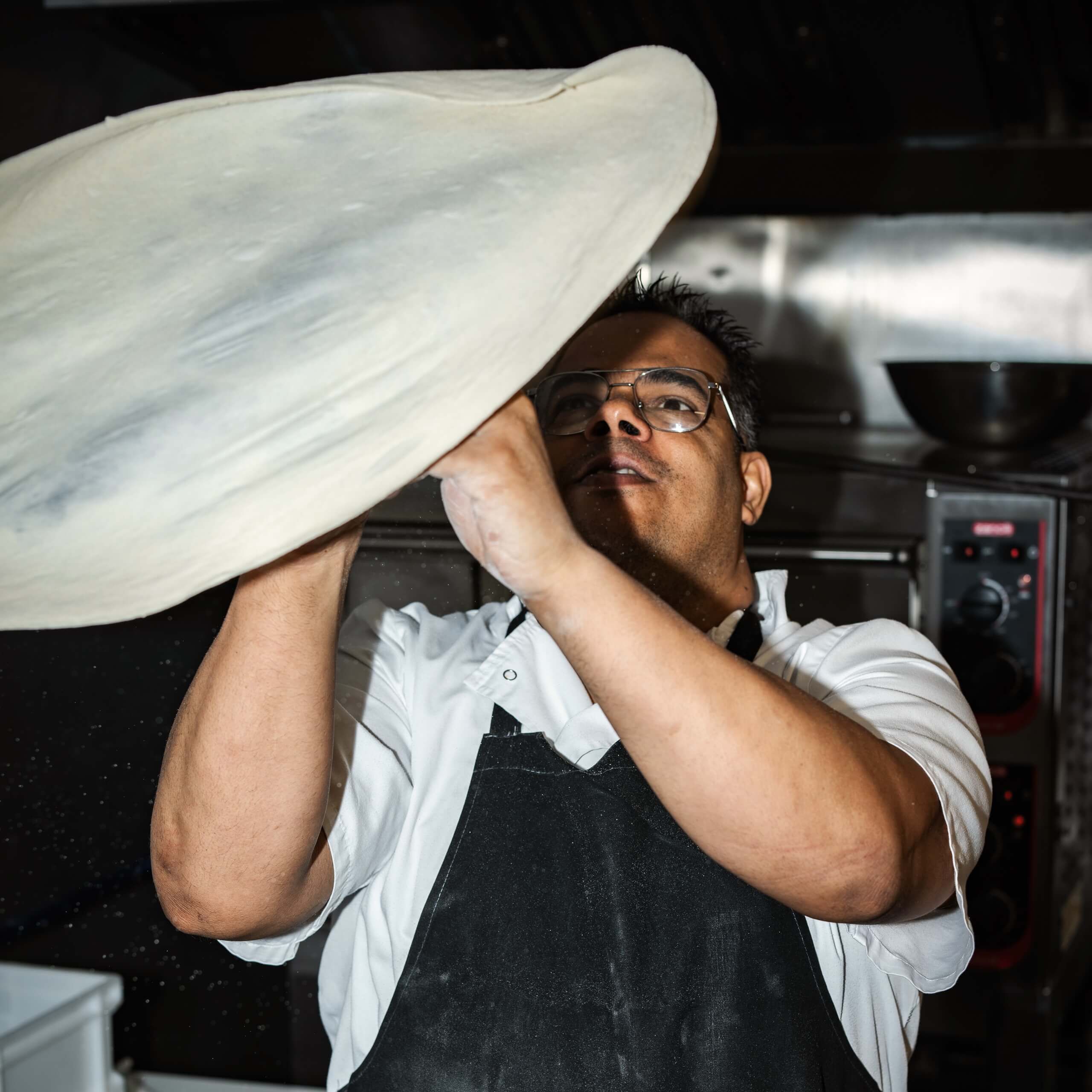 Chef throws pizza dough