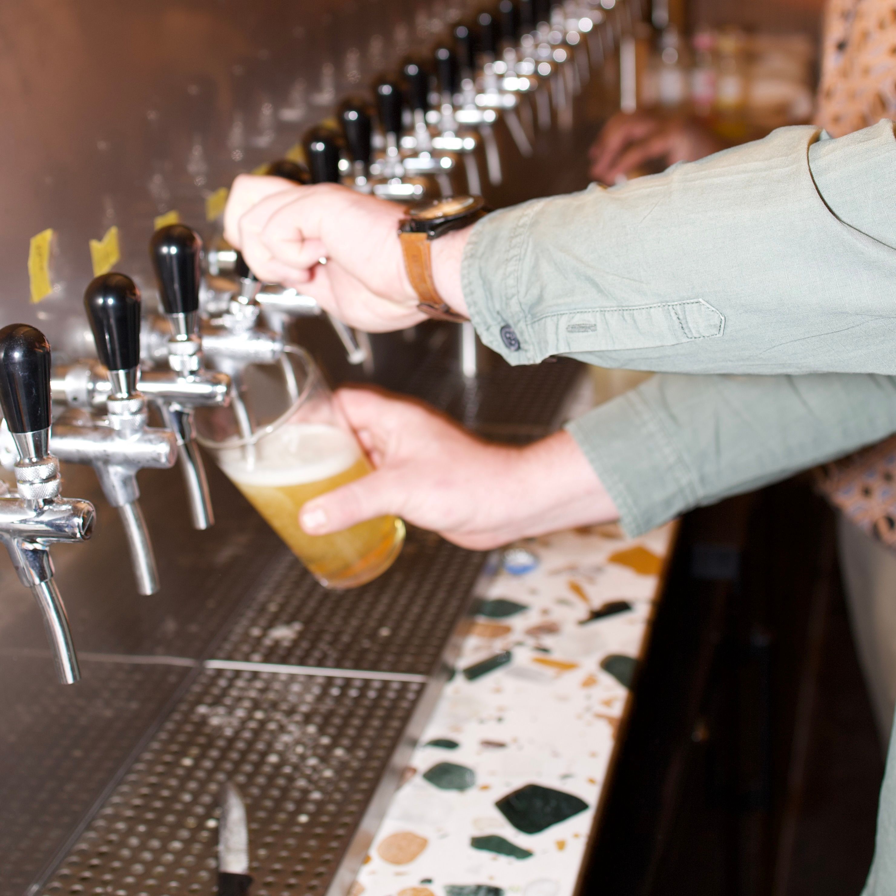 A staff member pours a beer from the taps at Trickle